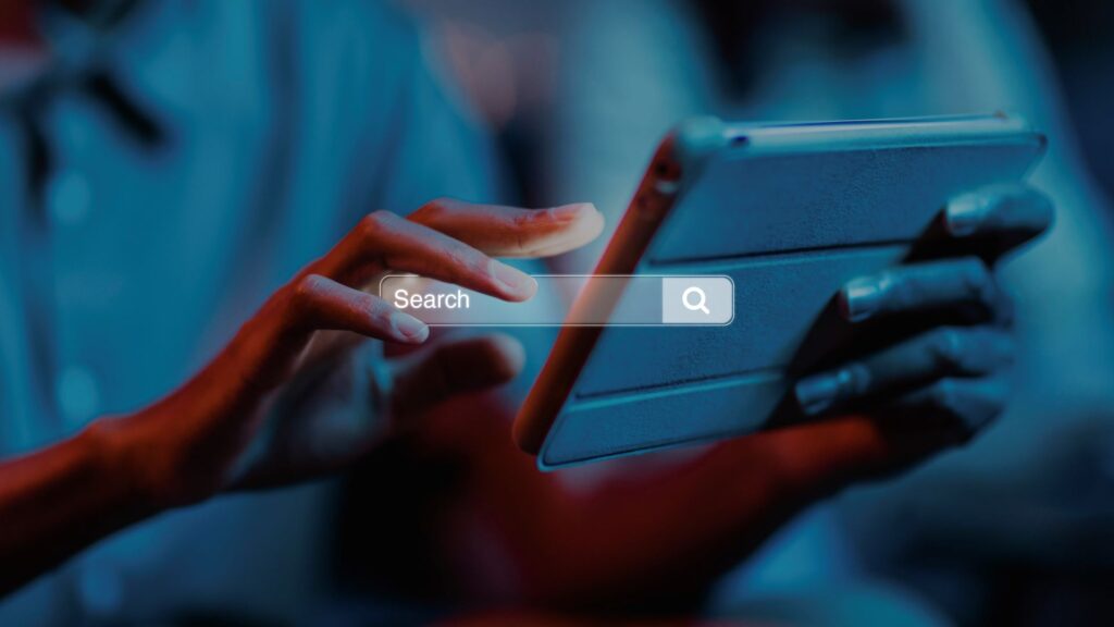 Hands operating a mobile digital tablet with an overlaid glowing search engine bar interface, representing conversational AI optimization and brand citation strength.